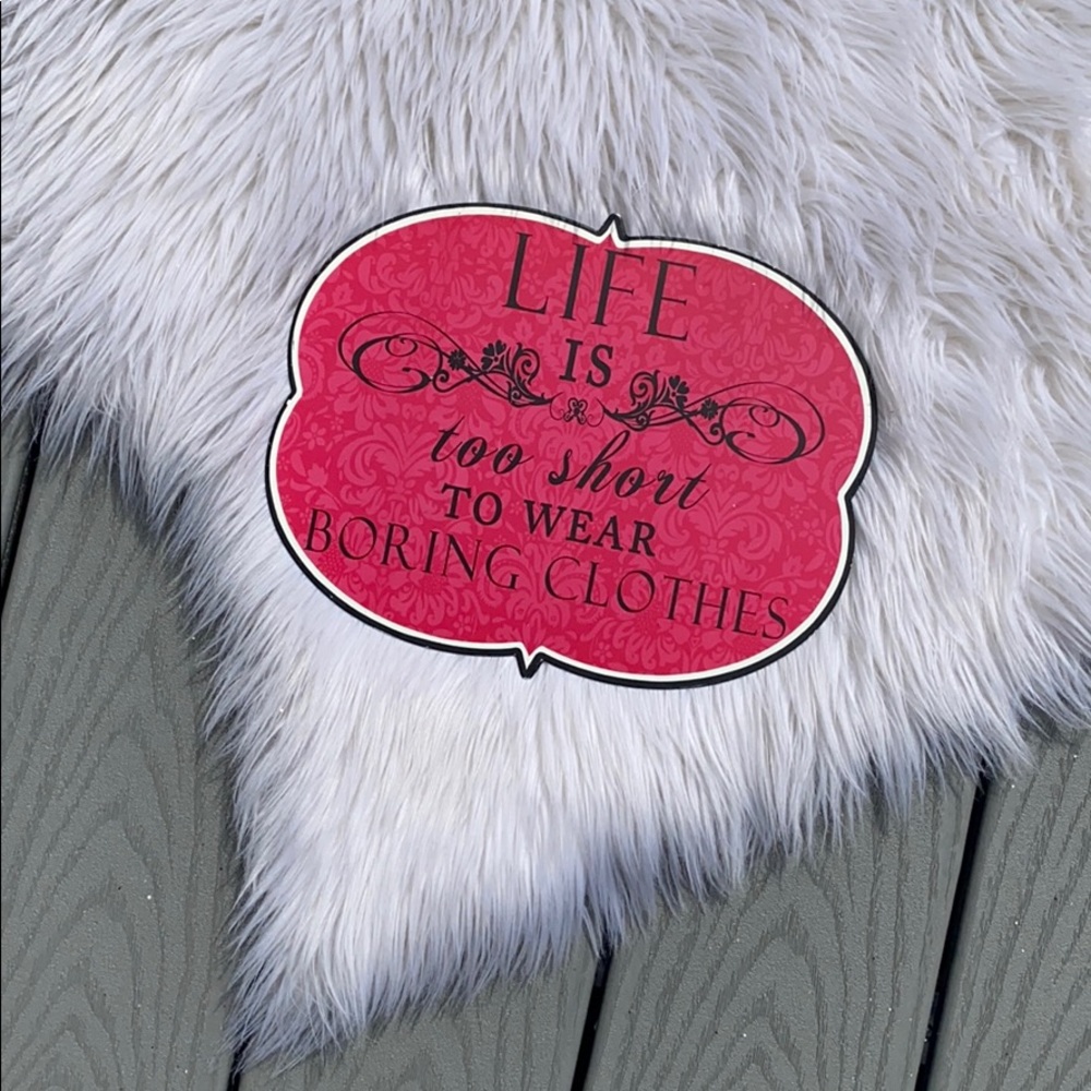 Pink metal wall sign with clothing quote